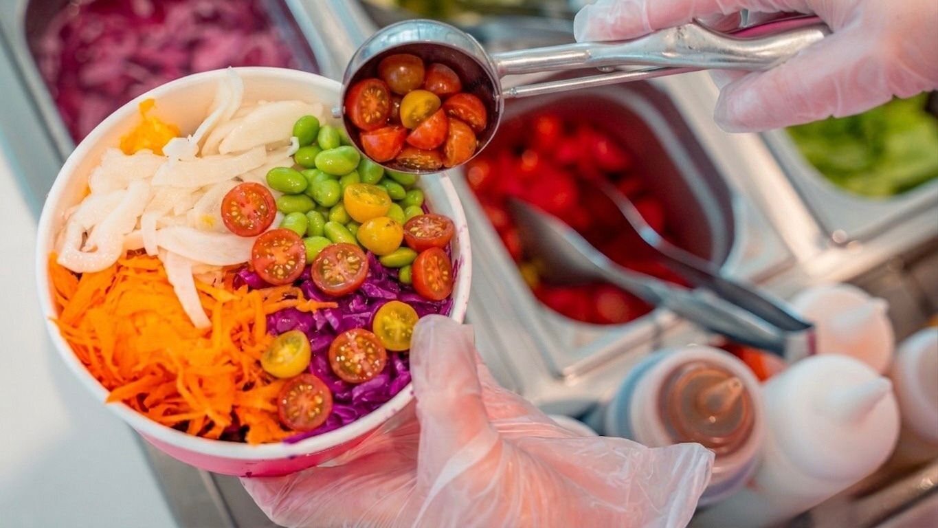 Composizione al banco di una bowl Manõ Poké con ingredienti freschi